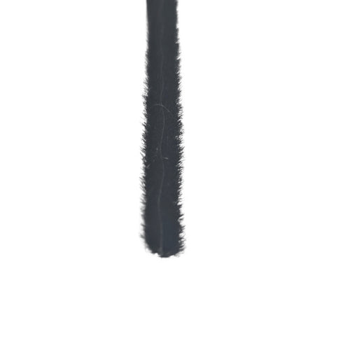 Close-up of a black eyelash extension on a white background